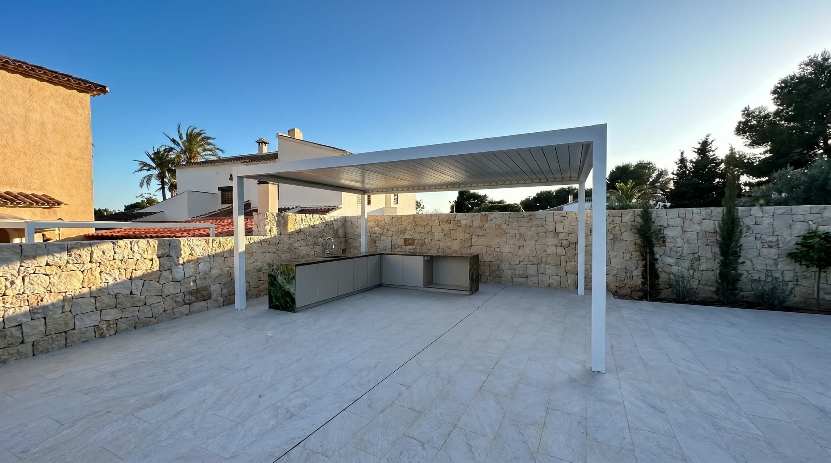Terraza reformada en Campoamor con toldo e isla de cocina exterior
